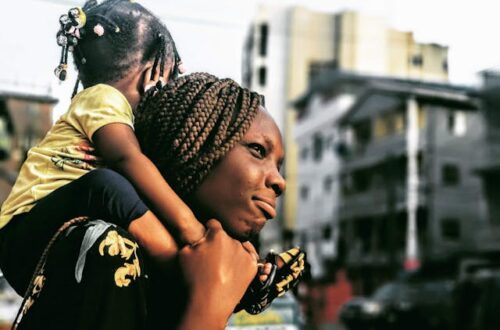 Black woman carrying a black child