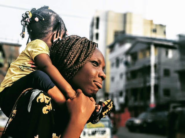 Black woman carrying a black child